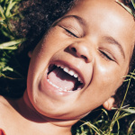 child on grass laughing