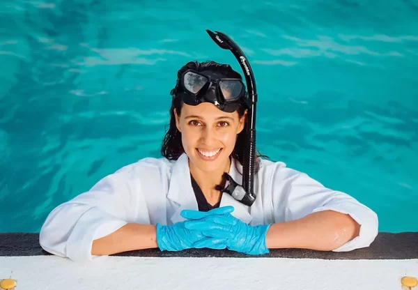 Woman in pool with lab coat and snorkel