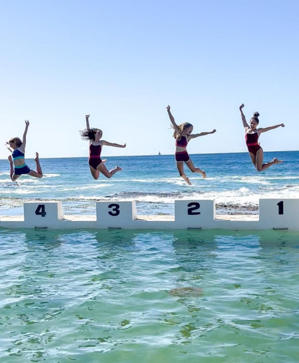 tween girls jumping into swimming pool
